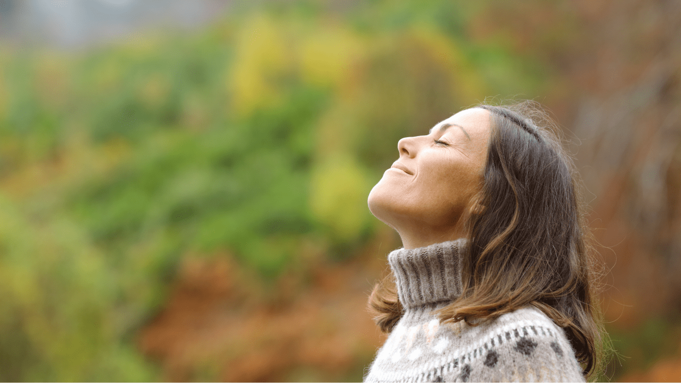 A young woman breathing deeply in the forest