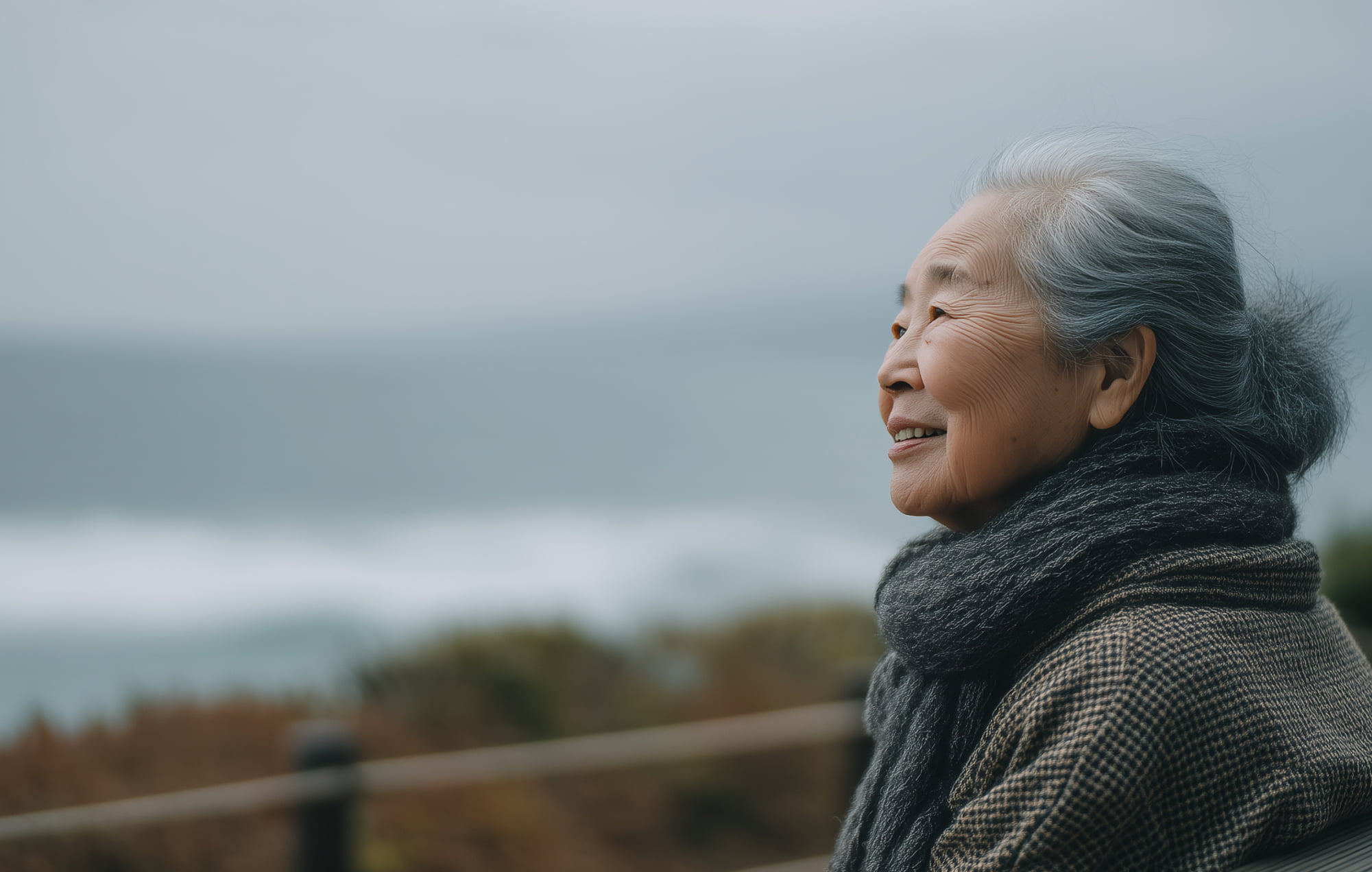 Old woman smiling and staring at the sea