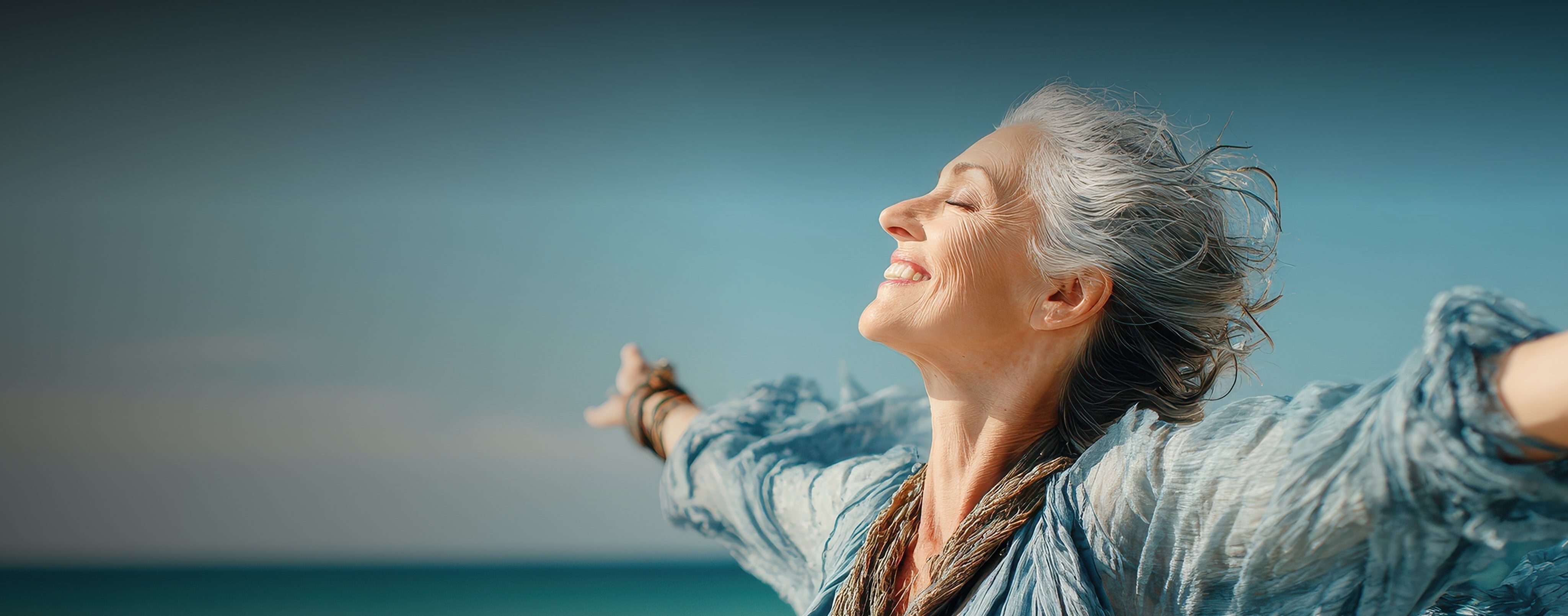 Woman smiling facing the sea and the sun