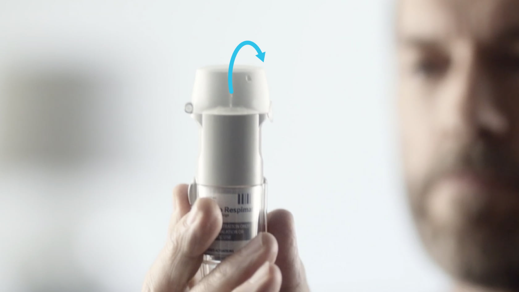 Hand flipping open the protective cap of a Spiriva Respimat inhaler