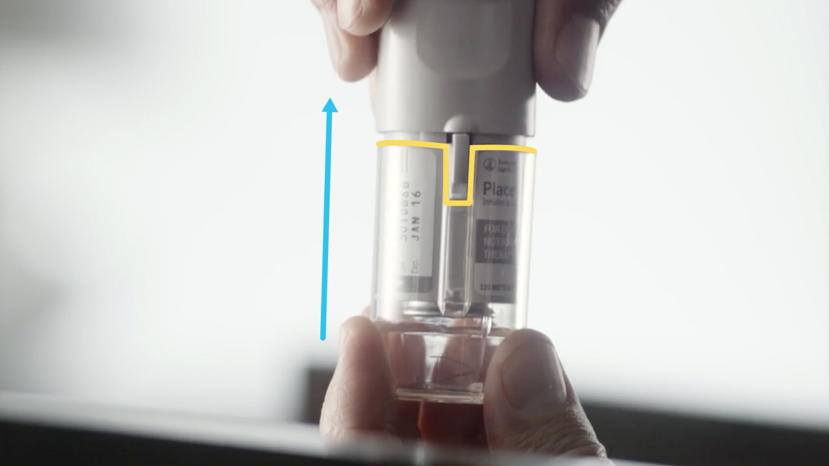 Hands pushing the clear base back onto the Spiriva Respimat inhaler until it clicks