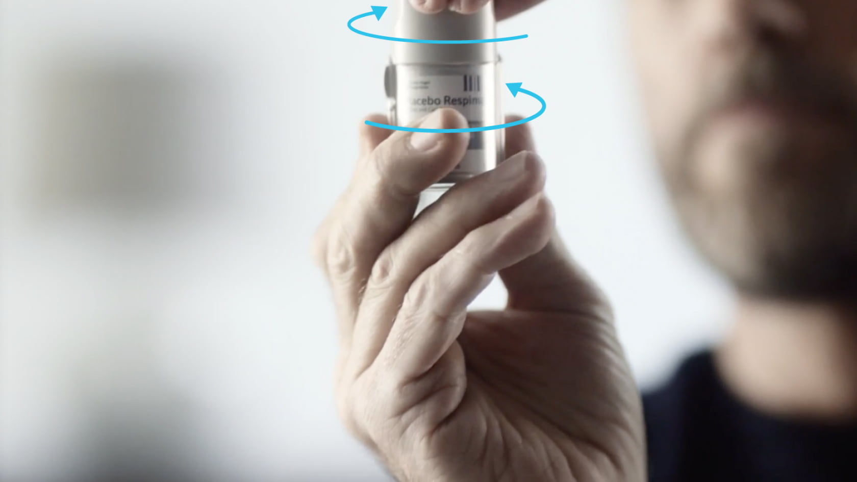 Hand twisting the clear base of a Spiriva Respimat inhaler