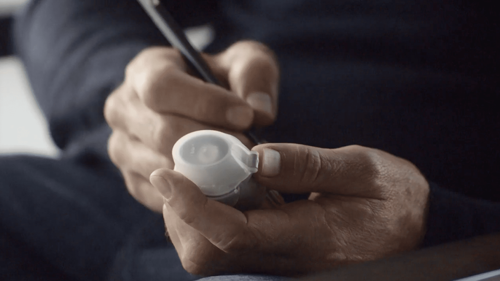 Hands writing the discard date on the label of a Spiriva Respimat inhaler