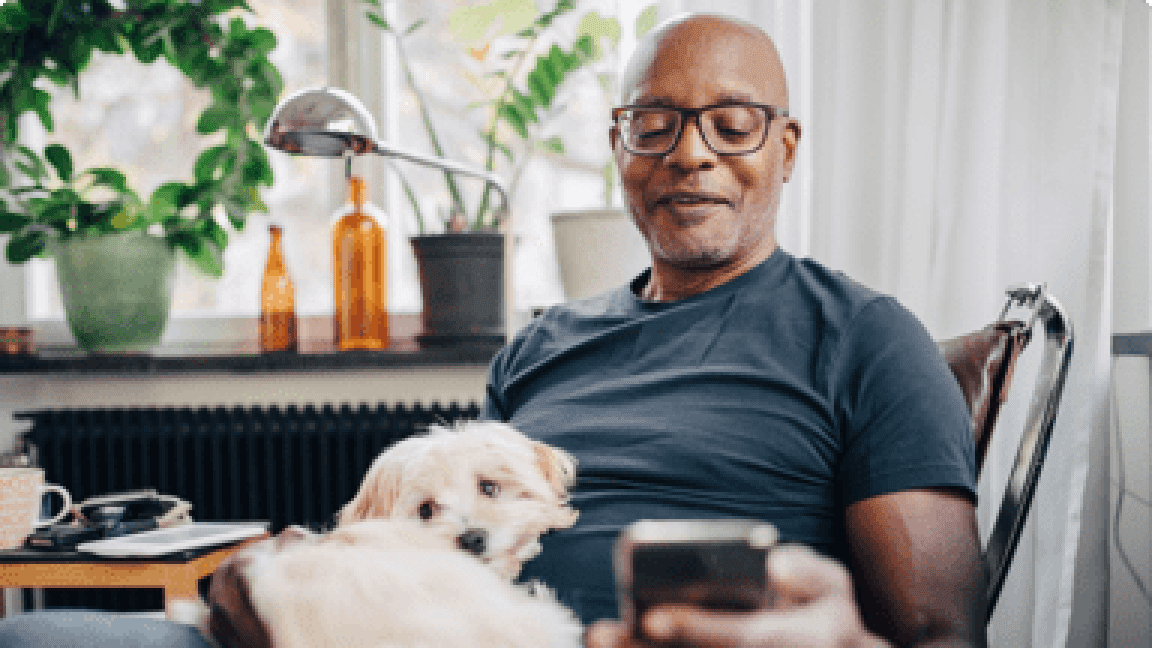 elder man sitting with a dog